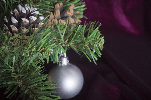 Artificial pine branch with Christmas decorations close-up