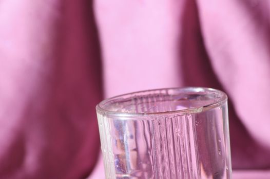 clear water glass pink background