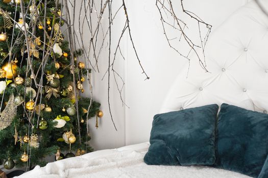 Bright white room with green pillows and canopy of branches - christmas decoration at home