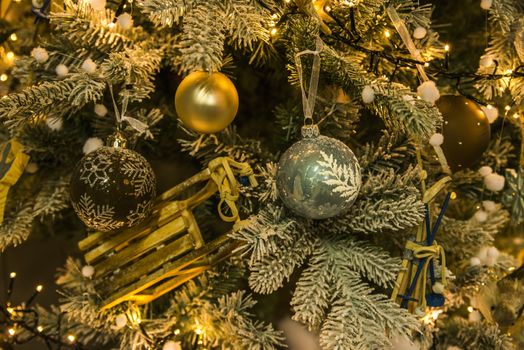 background of christmas tree with decorations in green and yellow gold