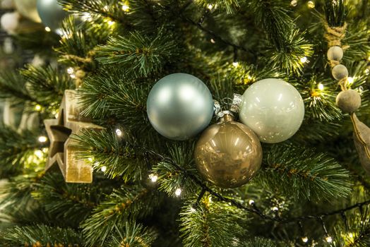 background of christmas tree with decorations in green and yellow gold