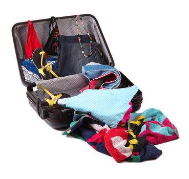 modern suitcase full of dress and objects on white background