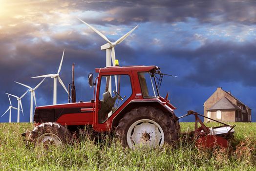 tractor at work in agricultural field with wind turbine