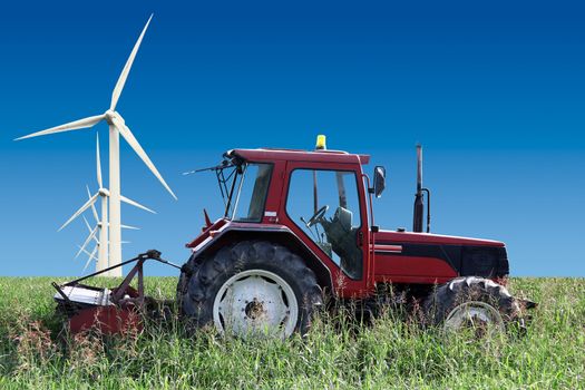 tractor at work in agricultural field with wind turbine