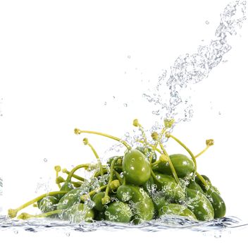Fresh capers falling in pure water