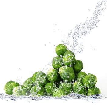 Fresh Brussels sprouts falling in pure water