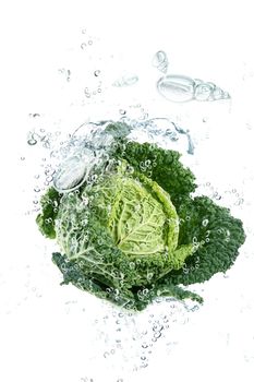 Fresh savoy cabbage falling in water