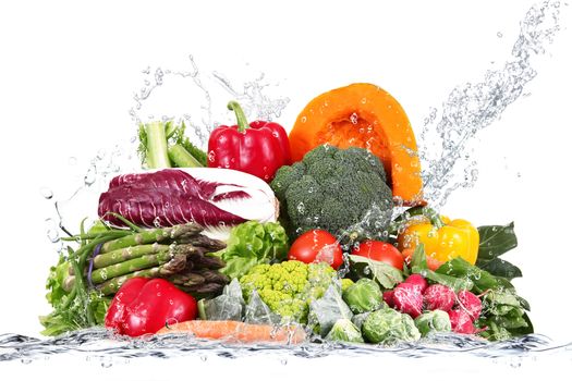 many fresh vegetables falling in water