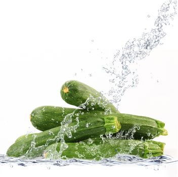 fresh courgette falling in pure water