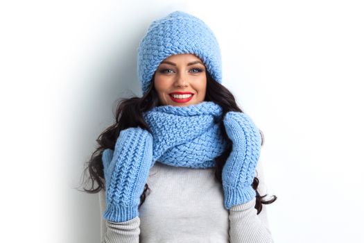 Beautiful woman in warm hat, mittens and scarf on white background