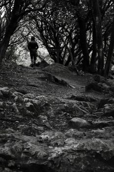 Rocky and abrupt path carries a girl to the hole between a bunch of trees