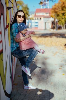 Mother and little daughter are walking and playing on the playground in the park. Authentic lifestyel image