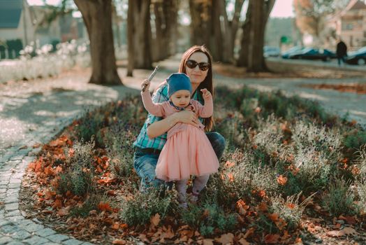 Mother and little daughter are walking and playing on the playground in the park. Authentic lifestyel image