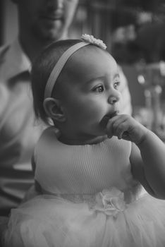 Baby girl 1 year old eating birthday cake in room. Birthday party. Childhood.