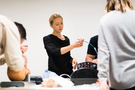 Medical doctor specialist expert displaying method of patient intubation technique on hands on medical education training and workshop.