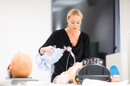 Medical doctor specialist expert displaying method of patient intubation technique on hands on medical education training and workshop.