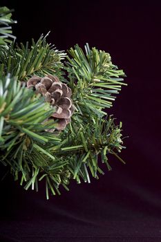 Close-up of artificial pine branch with pine cone