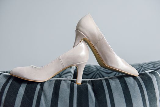 The bride shows white wedding shoes. Wedding detail. Close up