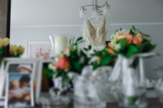 Bridesmaid helping slender bride lacing her wedding white dress, buttoning on delicate lace pattern with fluffy skirt on waist. Morning bridal preparation details newlyweds. Wedding day moments, wear.