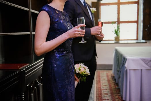 Bottle of cold vodka and wine bottle in bucket with ice and orange juice in jug on table, copy space. Alcohol bottles in ice bucket in restaurant. Wedding party