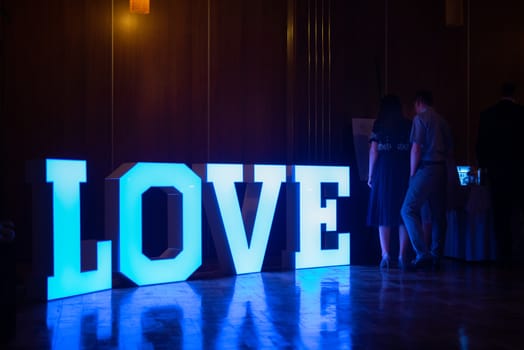 Illuminated Love sign in large letters at a wedding reception.