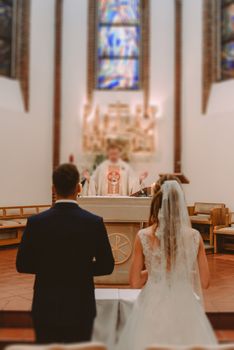 Bride and groom at church wedding during ceremony. Beautiful decoration