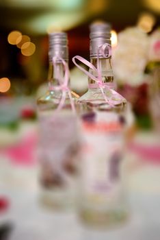Bottle of cold vodka and wine bottle in bucket with ice and orange juice in jug on table, copy space. Alcohol bottles in ice bucket in restaurant. Wedding party