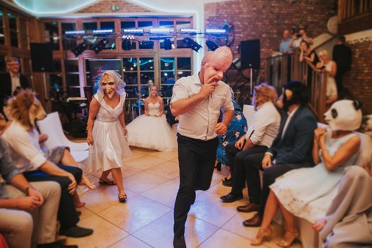 Bride and groom dancing the first dance at their wedding day. Guest on the dancefloor