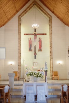 Church sanctuary before a wedding ceremony. Empty chairs for bride and groom