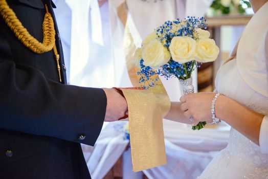 the bride and groom during the wedding ceremony put wedding rings on their fingers.