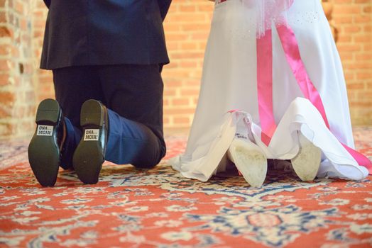The bride shows white wedding shoes. Wedding detail. Close up