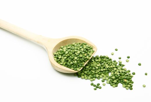 dry peas on wooden spoon on white background