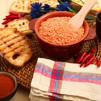 dry orange lentils in rustic dish on wooden table