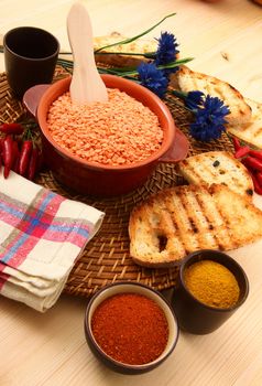 dry orange lentils in rustic dish on wooden table