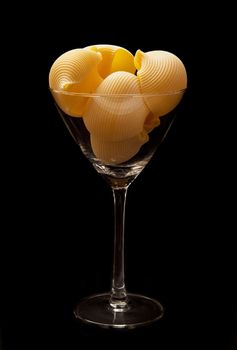 italian pasta in to glass on black background