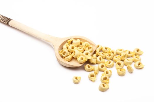 wood spoon with italian raw pasta on white background