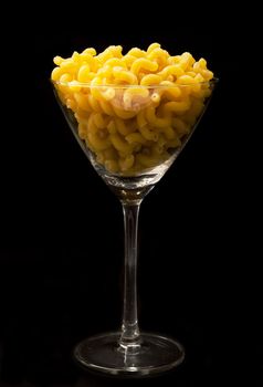 italian pasta in to glass on black background