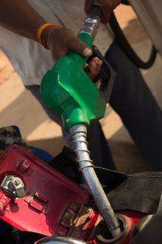 Person filling the Petrol using oil dispenser to bike petrol tank close up