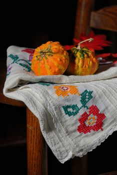 raw pumpkins on rustic chair on black background