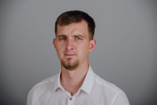 Portrait of a smiling young brunette man in studio