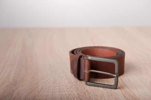 Leather belt on the wooden desk table