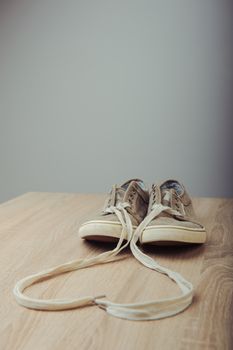 Blue lovely used sneakers on wooden desk