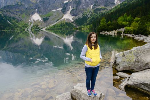 woman relaxing on the lake and mountains sunny landscape.