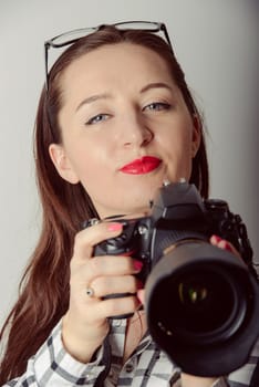 Woman-photographer takes images, isolated on gray background