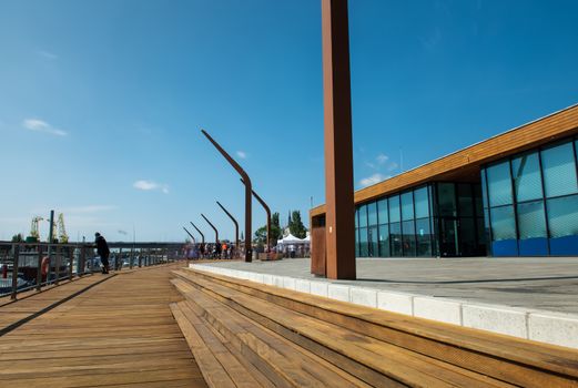 Modern and wooden marina club building in Szczecin, Poland. Boats, motorboat moored at the bank.