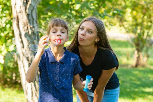 Girl and girl blow bubbles together