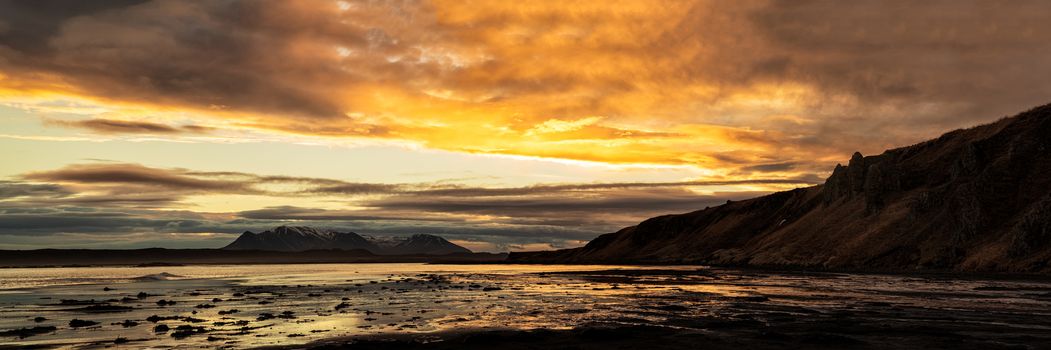 Mountains and ocean near Hvitserkur in Iceland at sunrise in Vatnsnes peninsula in panoramic view