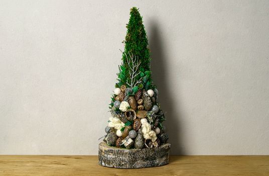 Handmade Christmas tree decoration made with acorns, nuts, seeds and moss