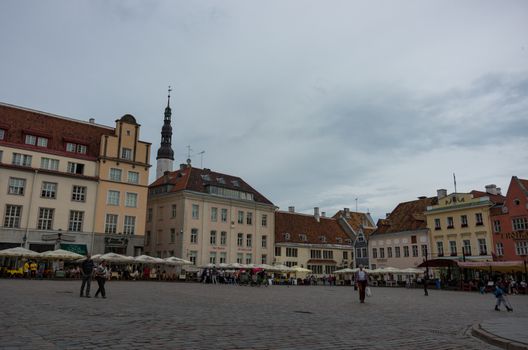 Tallinn, Estonia - July 29, 2017:  Tourists crowd the sidewalk cafes and shops in the medieval Tallinn Town Square in the walled city of Tallinn Estonia.