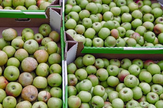 Seasonal fruits are placed in boxes in the grocery store. Close-up of fresh delicious apples. Natural foods rich in vitamins for a healthy diet.